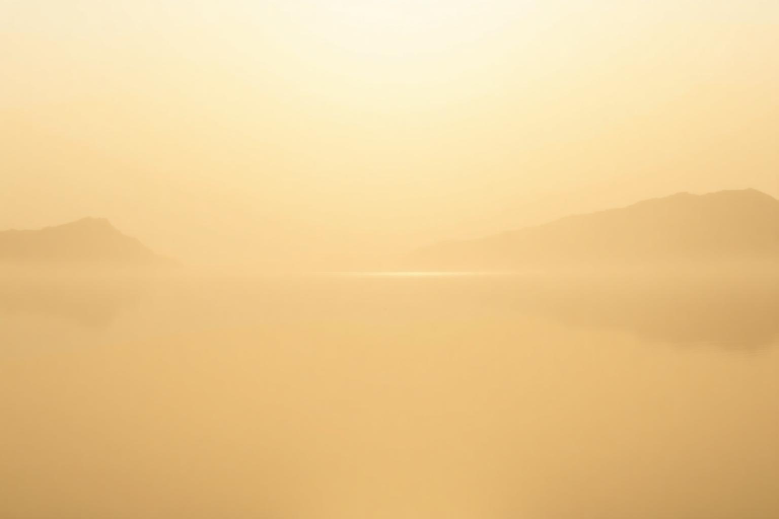 Golden dawn light over a calm lake